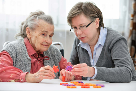 Caregiver working on a puzzle with elderly woman