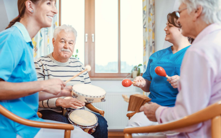 Caregivers and elerly playing music together