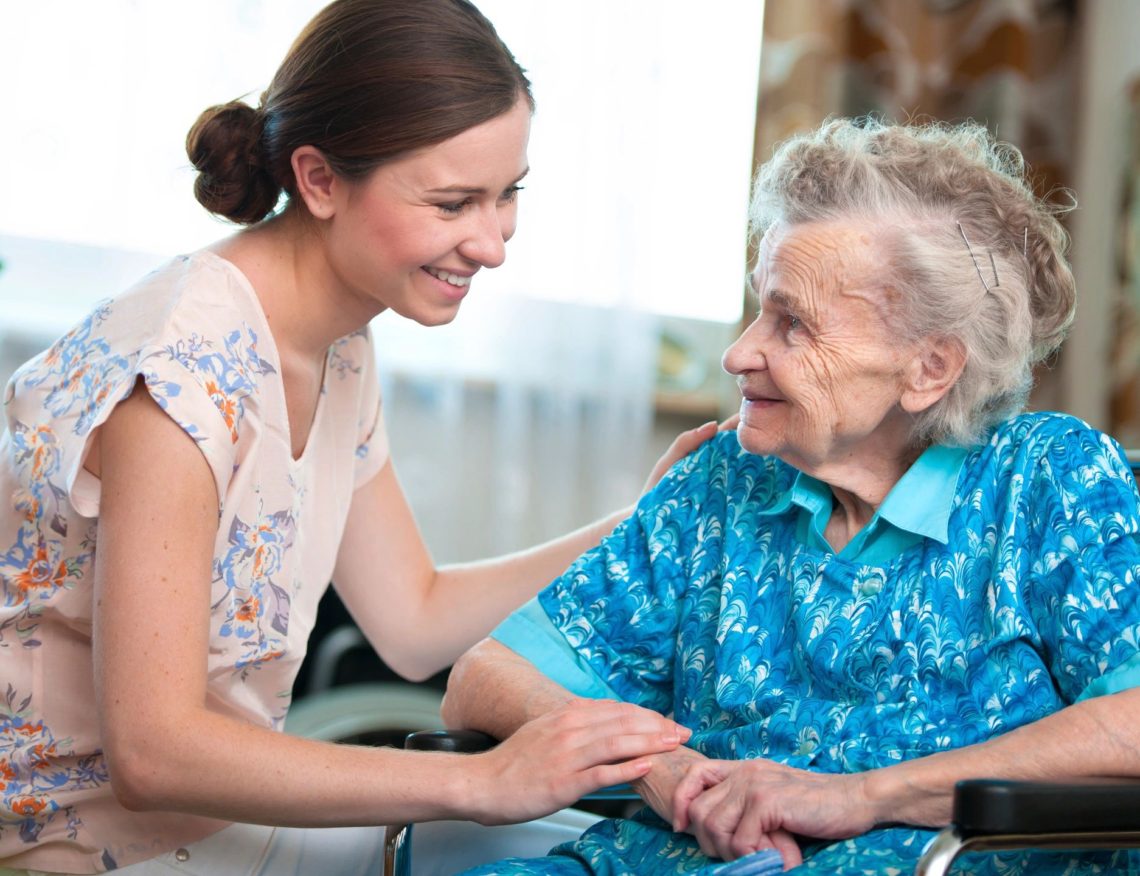 Caregiver helping elderly woman