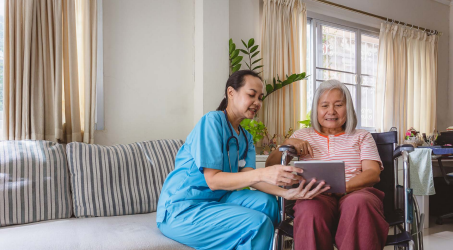 Nurse showing elderly woman a tablet